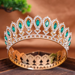 Luxurious gold baroque crown with emerald green gems and sparkling white rhinestones