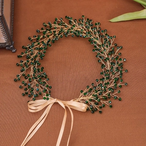 Detail of handmade gold wire hairpiece with green crystal beads and champagne ribbon