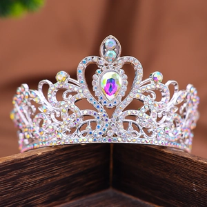 Dettaglio di una corona in strass argento con motivi a cuore su scatola di legno vintage