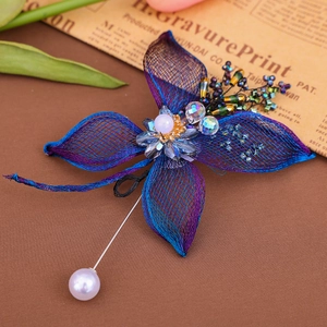 Macro detail of handmade gradient mesh flower brooch with blue crystal and pearl