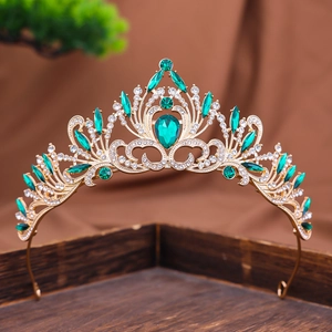 Detailed macro of Baroque gold crown with emerald green crystals and sparkling rhinestones