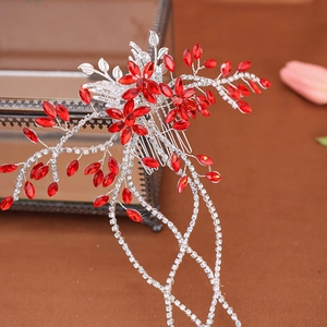 Detail of red crystal bridal hair comb with silver leaf motifs and sparkling tassels