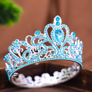 Dettaglio della corona d'argento con strass blu e cristalli a goccia su base di legno