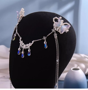 Close-up of pearl butterfly clips with long tassels and blue teardrop pendants