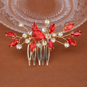 Peigne à cheveux de mariée avec strass rouges et design floral doré sur surface brune