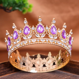 Close-up of golden crown with purple teardrop crystals and sparkling white rhinestones