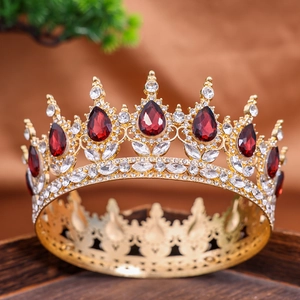 Detail showing red teardrop gemstones and white rhinestones on a gold wedding crown