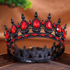 Vintage black alloy crown with red teardrop rhinestones on dark wooden tray
