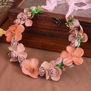 Ghirlanda di fiori marrone con rose rosa e nastro di chiffon su una scatola di legno vintage