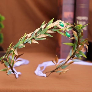 Detailed view of forest elf crown with green leaves, gold accents and drop gem