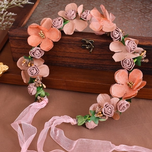 Dettaglio di una fascia floreale con fiori di seta rosa e bacche su scatola d'epoca