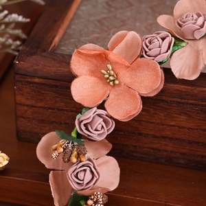Dettaglio fascia per capelli vintage con rose di stoffa e bacche dorate