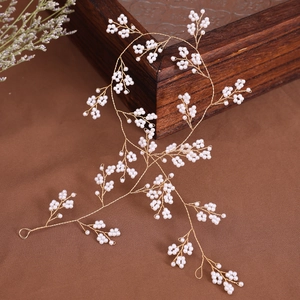 Detail of handcrafted bridal headband with gold wire weaving and small white pearls