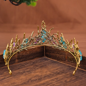 Detail of vintage gold crown with raw blue crystals and branch texture on wood