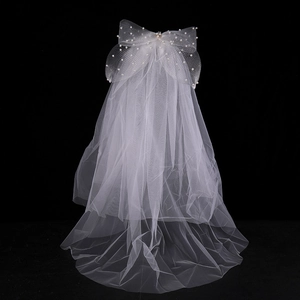 Detailed view of the layered white bridal veil with pearl bow and floral rhinestones