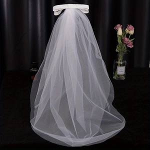 Detail view of double-layer white wedding veil with elegant bow and delicate mesh texture