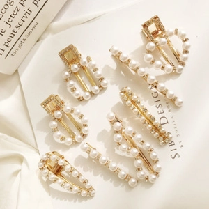 Detail showing 8-piece gold hair clip set with white pearls and sparkling rhinestones