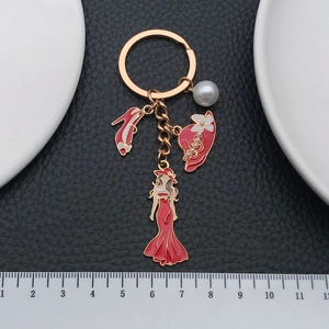 Elegant gold keychain with red enamel dress, high heel and hat charms on black leather