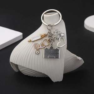 Close-up of antique silver medical keychain with syringe, stethoscope and hospital charms