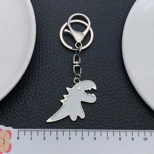 Creative white dinosaur keychain with silver alloy frame and lobster clasp on dark leather