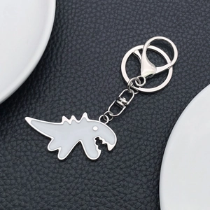 Detailed macro view of the silver lobster clasp and grey dinosaur keychain accessory