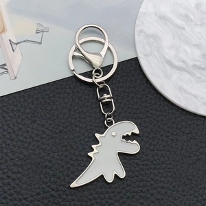 Detailed view of a white dinosaur keychain with silver metal lobster clasp and ring