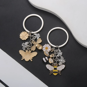 Detailed macro view of bee and daisy pendants with enamel oil and rhinestone inlay