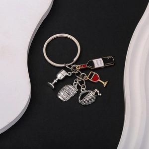 Detail of red wine themed keychain with miniature bottle, barrel, and glass charms