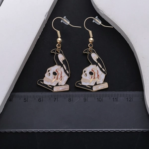Gothic Raben- und Totenkopf-Ohrringe mit Emaille-Finish auf schwarzem Hintergrund