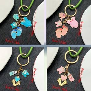 Detail view of baby shower keychains showing elephant and bottle charms with dimensions