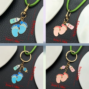 Detail showing baby bottle and footprints enamel keychain dimensions and silicone strap