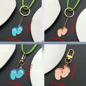 Detailed size view of pink and blue enamel baby footprint keychains with metal lobster clasps