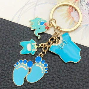 Blue baby themed keychain with elephant and baby footprints on black leather background