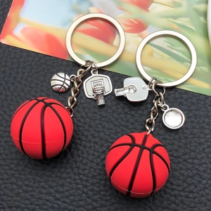 Creative red basketball keychain with metal sports charms on textured black background