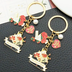 Détail d'un porte-clés fête des mères en émail avec œillets rouges et perle synthétique