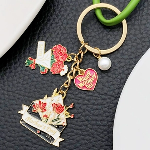 Gros plan du porte-clés fête des mères avec oeillets rouges et pendentifs en émail rose