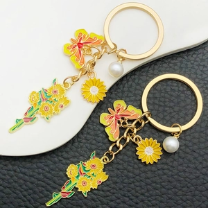 Sunflower and yellow butterfly keychain with pearl charm on leather background