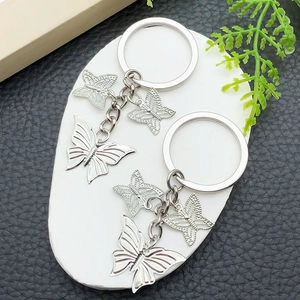 Set of two silver butterfly keychains with hollow and solid engraved metal pendants