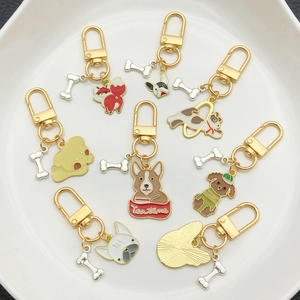 Cartoon dog enamel keychains set with Corgi and Bulldog designs in a white ceramic dish