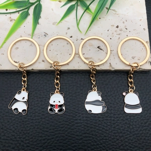 Set di quattro portachiavi panda con cornici dorate e dettagli in smalto bianco e nero