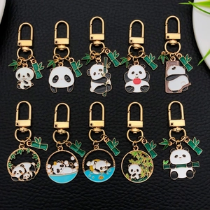 Set di 10 portachiavi in metallo a forma di panda con varie pose su sfondo in pelle nera
