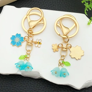Floral and bee enamel keychains with blue lily of the valley beads on a gold ring