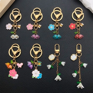Close-up of eight floral acrylic keychains with lily and butterfly on leather