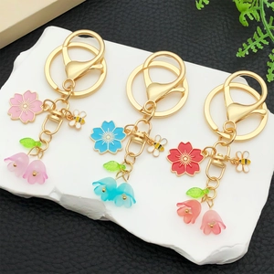 Floral acrylic butterfly and lily of the valley keychains in three colors on a stone tray