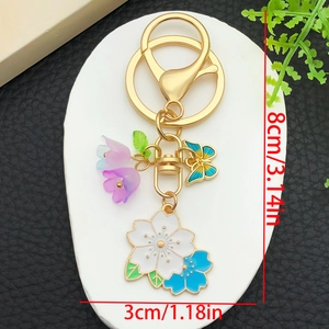 Floral gold keychain with blue cherry blossoms, butterfly charms and purple bellflower