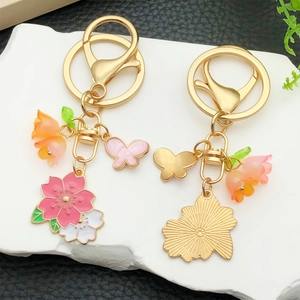 Porte-clés fleurs de cerisier roses et lys orange avec charm papillon pour sac à main