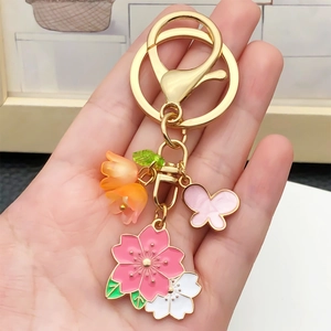 Porte-clés fleurs de cerisier et papillon avec breloques dorées en dégradé rose