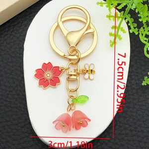Floral keychain with red sakura bee and lily of the valley pendants measuring 7.5cm by 3cm