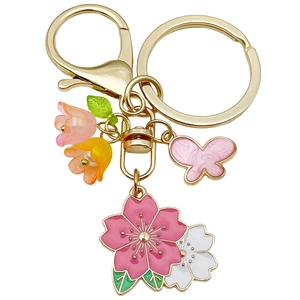 Porte-clés fleurs de cerisier rose avec papillon et fleurs sur une attache dorée