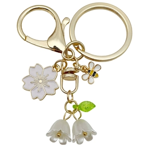 Porte-clés doré fleur de cerisier et abeille avec breloques de muguet blanc